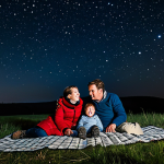 Family Stargazing Night**

"A family of four, fully clothed in warm, modest clothing, lying on a blanket in a field at night, looking up at the stars. They have a small red flashlight and a star chart.  Gentle, awe-inspired expressions.  Background shows a dark sky with a visible Milky Way. Safe for work, appropriate content, professional photography, perfect anatomy, correct proportions, family-friendly, rural setting, clear night sky."

**